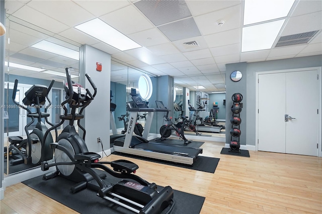 gym with hardwood / wood-style floors and a paneled ceiling