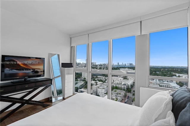 bedroom with a city view and wood finished floors