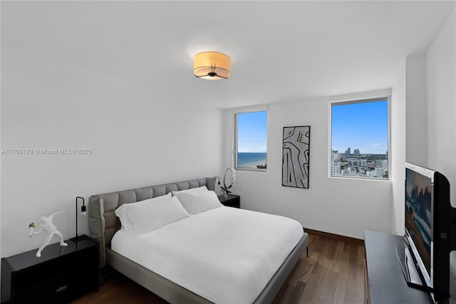 bedroom featuring dark wood-style flooring and baseboards