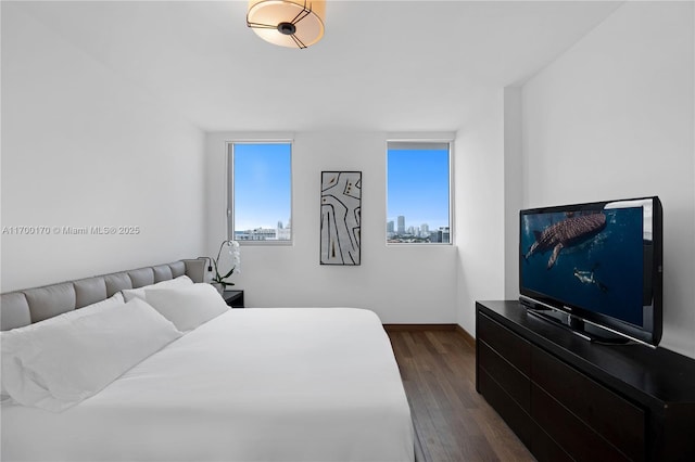 bedroom featuring baseboards and dark wood-type flooring