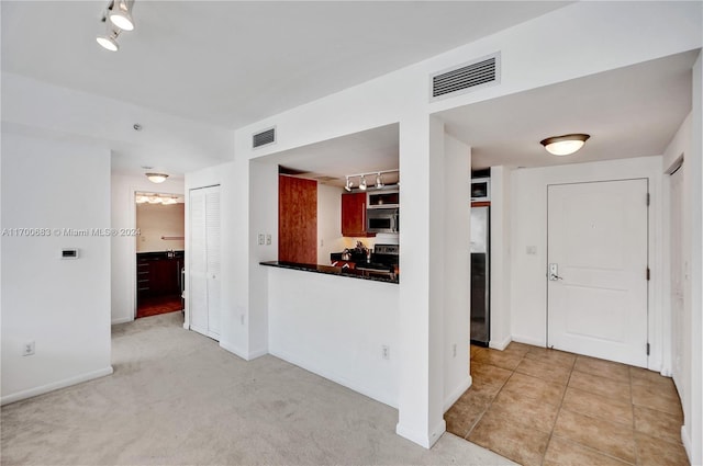 empty room with light colored carpet and track lighting