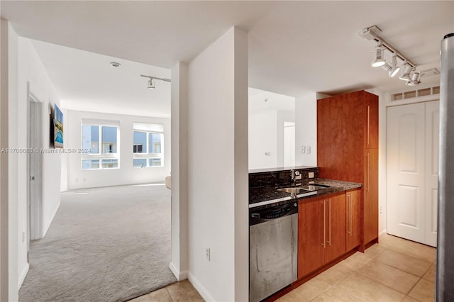 kitchen with track lighting, sink, dishwasher, and light carpet