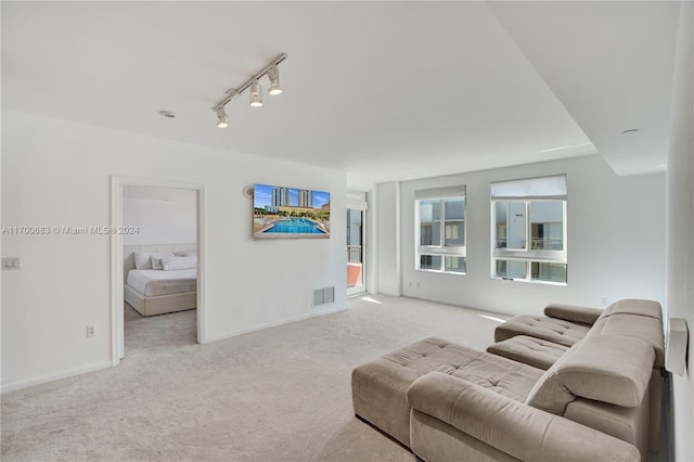 living room with light carpet and rail lighting