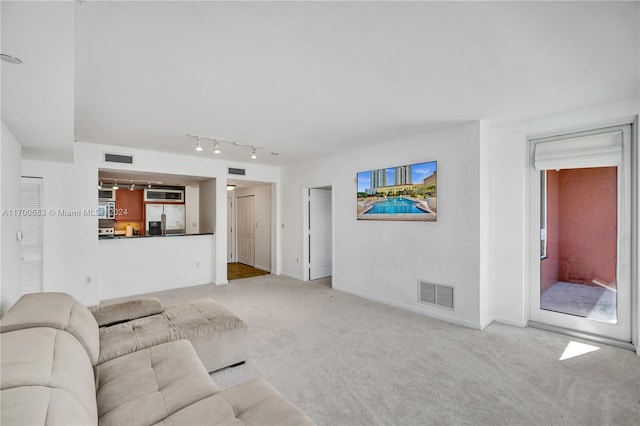 unfurnished living room with light carpet and rail lighting