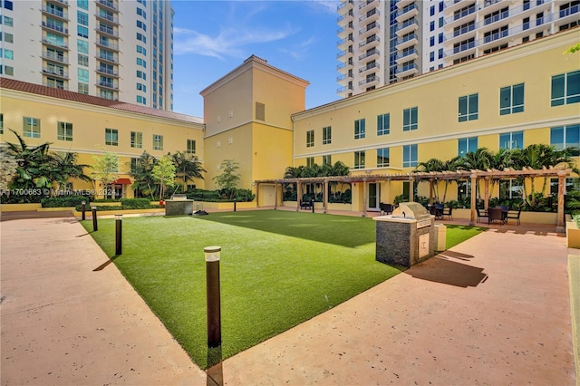 view of community featuring a yard and a pergola