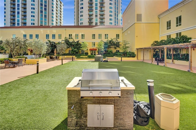 view of community featuring a patio area, a yard, and area for grilling