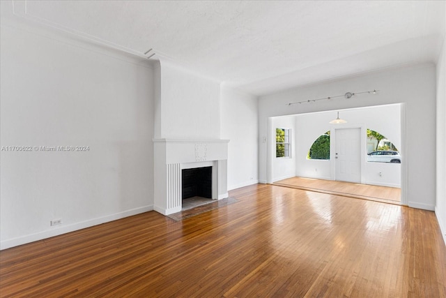 unfurnished living room featuring hardwood / wood-style floors, a fireplace, and a textured ceiling