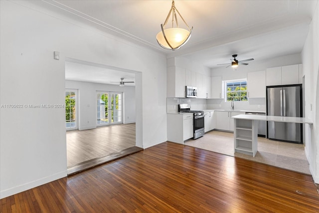 kitchen with white cabinets, stainless steel appliances, and light wood-type flooring