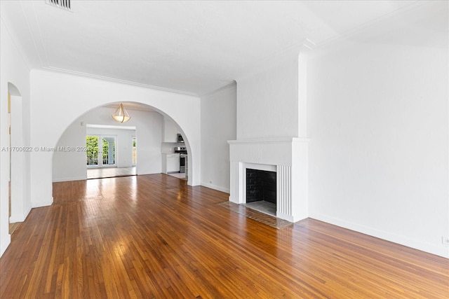 unfurnished living room with hardwood / wood-style floors and ornamental molding