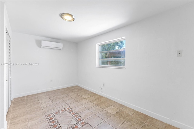 tiled spare room featuring an AC wall unit