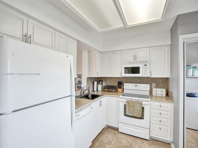 kitchen with decorative backsplash, white cabinetry, sink, and white appliances