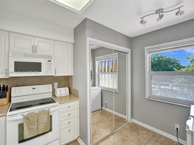 kitchen featuring a textured ceiling, white appliances, white cabinetry, and light tile patterned flooring