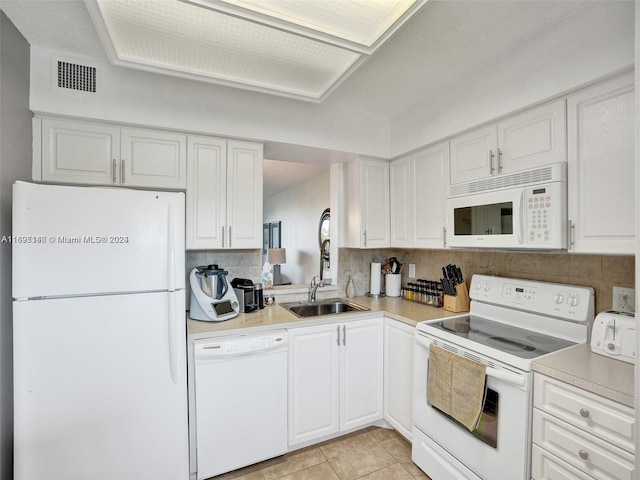 kitchen featuring white cabinetry, sink, tasteful backsplash, white appliances, and light tile patterned floors