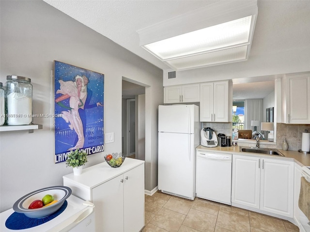 kitchen featuring light tile patterned floors, white appliances, white cabinetry, and sink