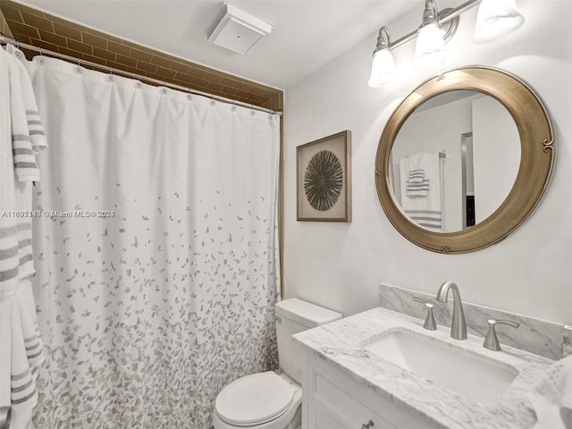 bathroom featuring a shower with shower curtain, vanity, and toilet