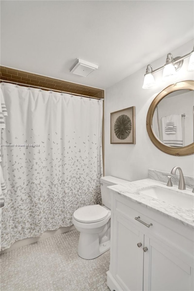 bathroom featuring tile patterned floors, vanity, and toilet