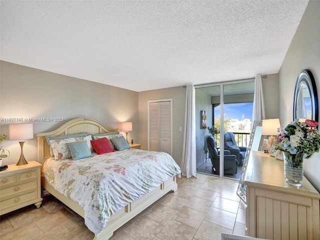 tiled bedroom featuring access to exterior, a textured ceiling, and a closet