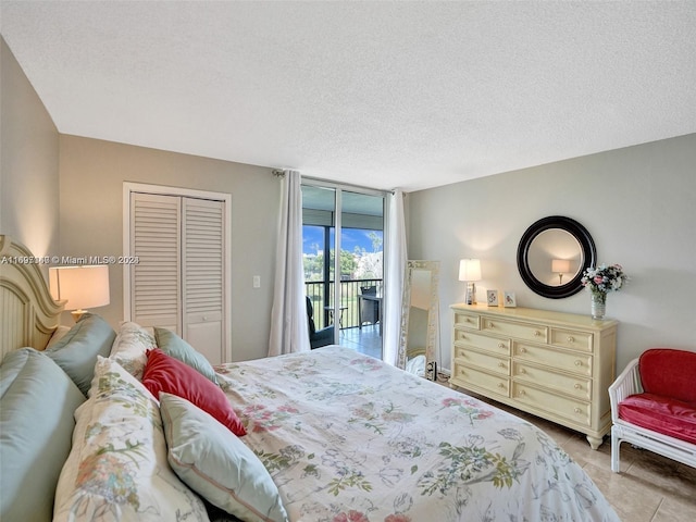 bedroom featuring access to exterior, a textured ceiling, and a closet