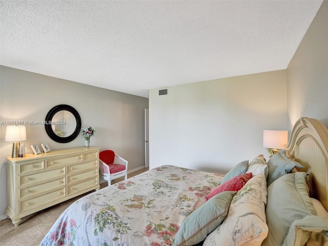 tiled bedroom with a textured ceiling