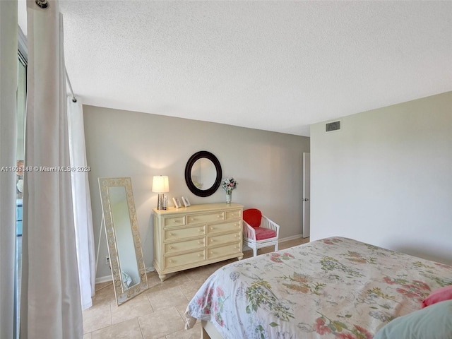 bedroom featuring light tile patterned flooring and a textured ceiling