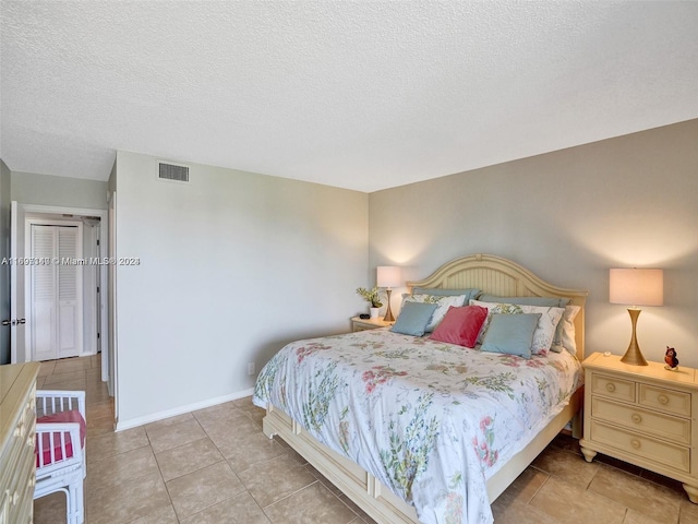 tiled bedroom with a textured ceiling