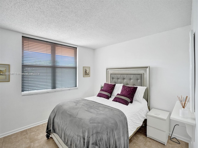 tiled bedroom featuring a textured ceiling