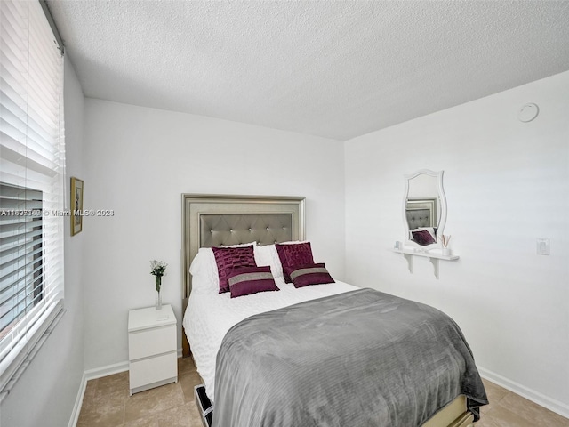 tiled bedroom with a textured ceiling