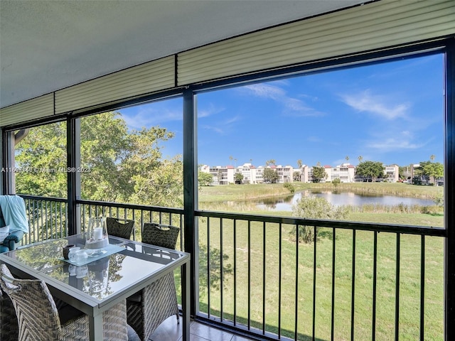 unfurnished sunroom featuring a water view