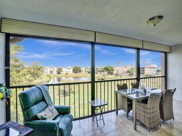 sunroom featuring a water view