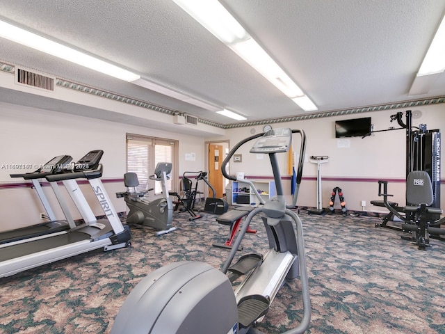 workout area with carpet flooring and a textured ceiling