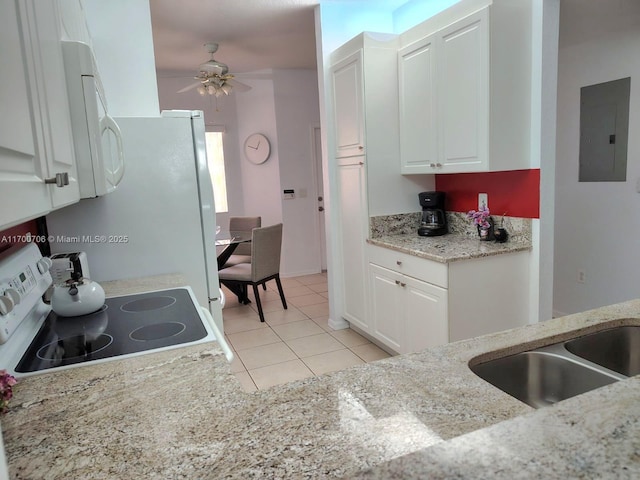 kitchen featuring ceiling fan, light tile patterned floors, range, electric panel, and white cabinetry