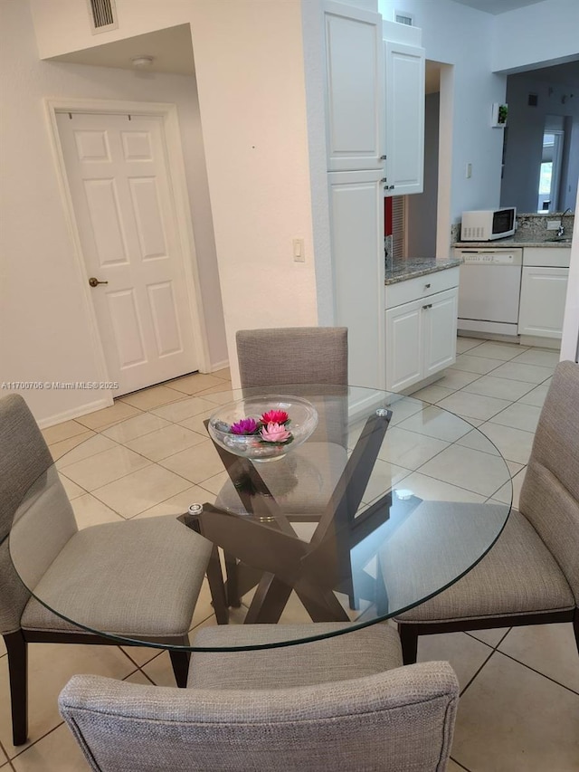 dining space featuring sink and light tile patterned flooring