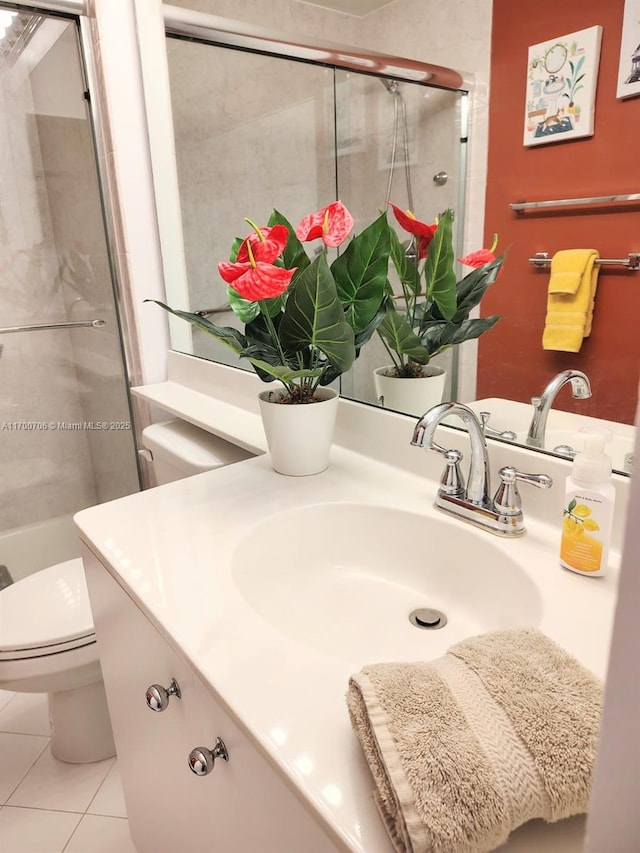 bathroom featuring tile patterned floors, a shower with door, vanity, and toilet