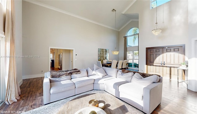 living room with an inviting chandelier, high vaulted ceiling, wood-type flooring, and ornamental molding