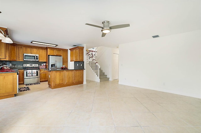 kitchen with ceiling fan, light tile patterned floors, appliances with stainless steel finishes, and tasteful backsplash