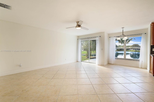 spare room with ceiling fan with notable chandelier and light tile patterned flooring