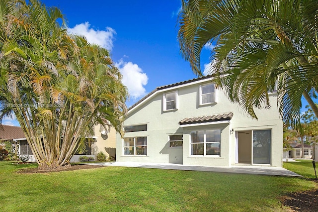 rear view of property with a patio area and a lawn