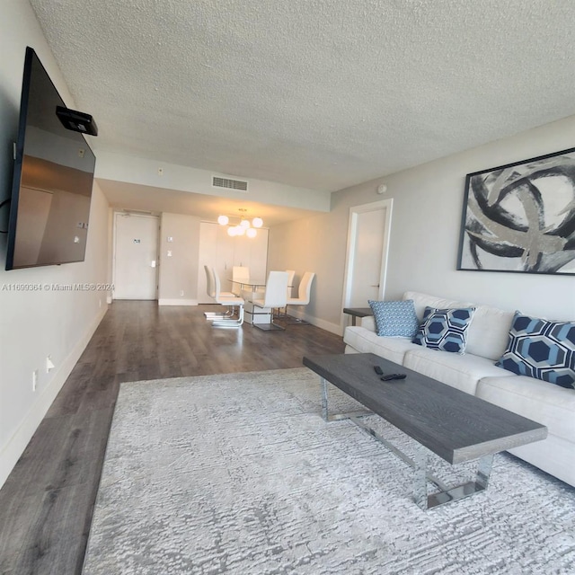 living room with dark wood-type flooring and a textured ceiling