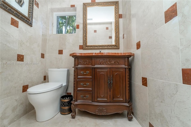 bathroom featuring vanity, toilet, and tile walls