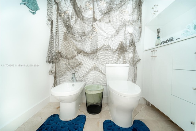 bathroom with tile patterned floors, toilet, and a bidet