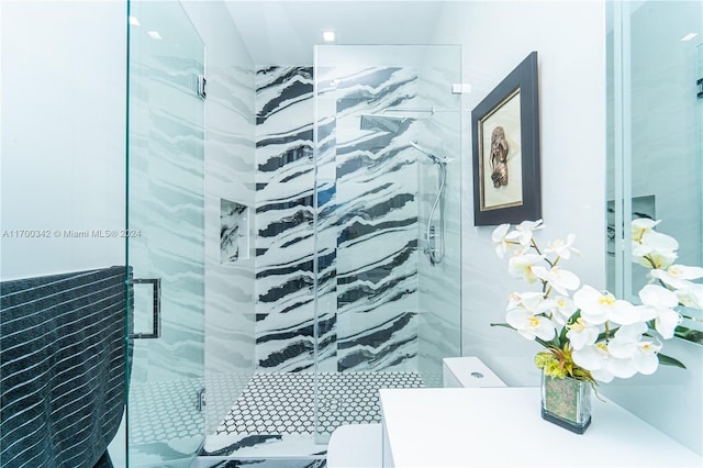 bathroom featuring toilet and a shower with shower door