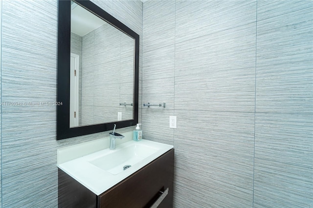 bathroom featuring vanity and tile walls