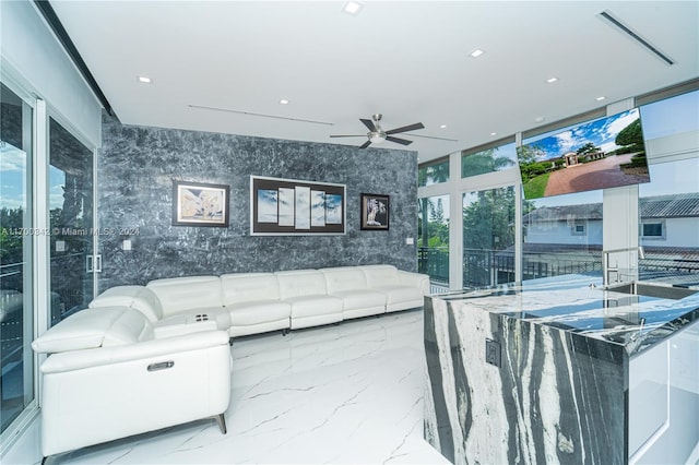 living room featuring plenty of natural light, floor to ceiling windows, and ceiling fan