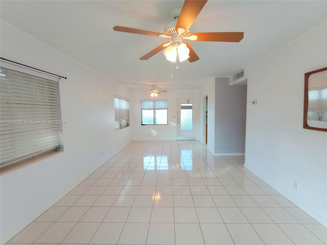 tiled empty room featuring ceiling fan