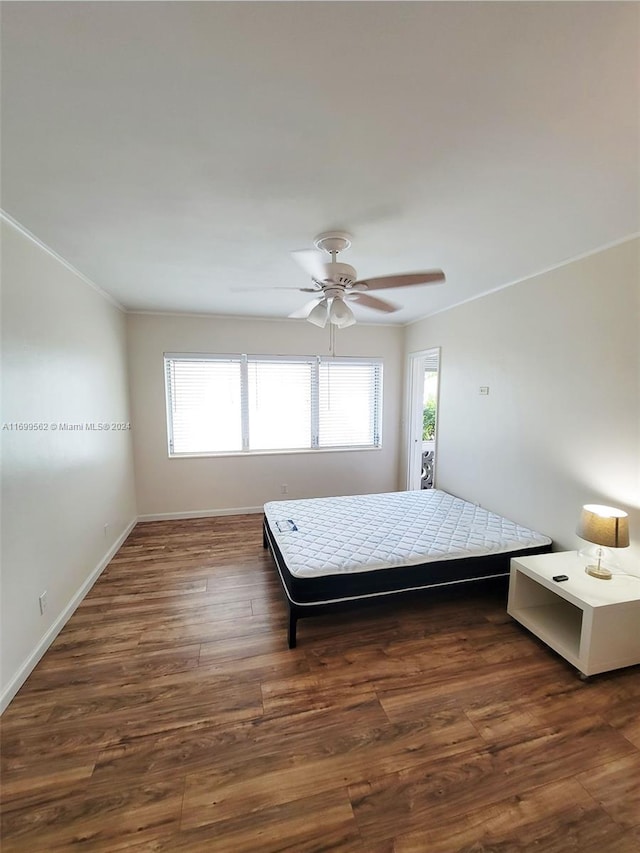 unfurnished bedroom with multiple windows, ceiling fan, dark hardwood / wood-style floors, and ornamental molding