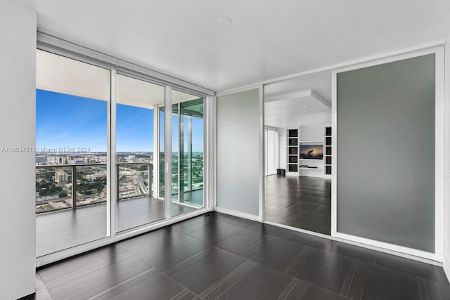 unfurnished room featuring a wall of windows