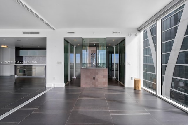 interior space with expansive windows and dark tile patterned flooring