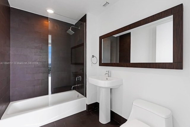 full bathroom featuring tiled shower / bath combo, toilet, and sink