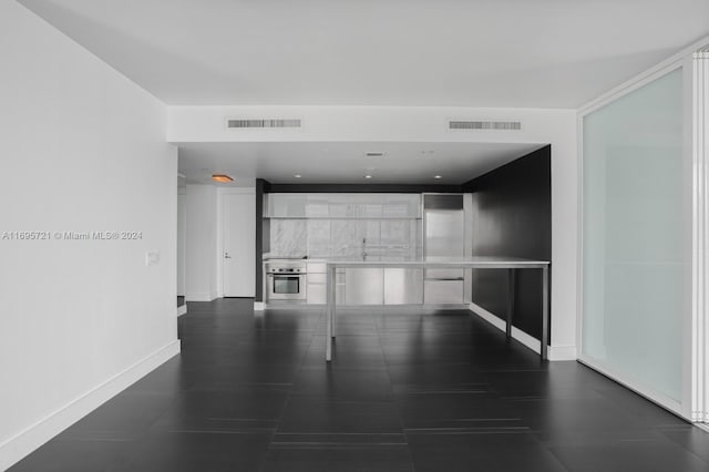 unfurnished living room with dark tile patterned flooring