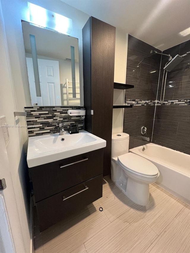 full bathroom featuring decorative backsplash, vanity, tiled shower / bath combo, and toilet